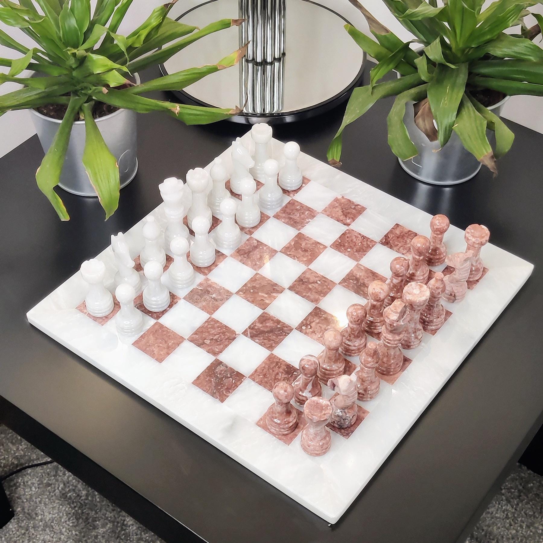 Marble chess set on a table in white and pink colour